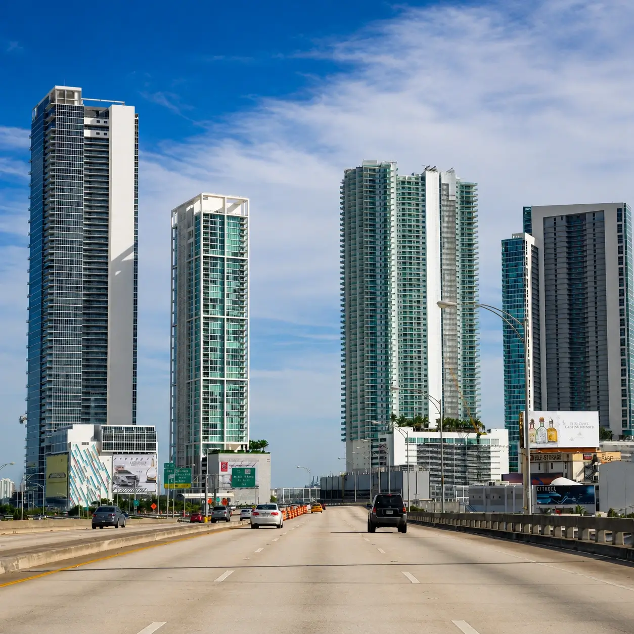 Road in Hallandale West Featuring tall apartment buildings against a blue sky