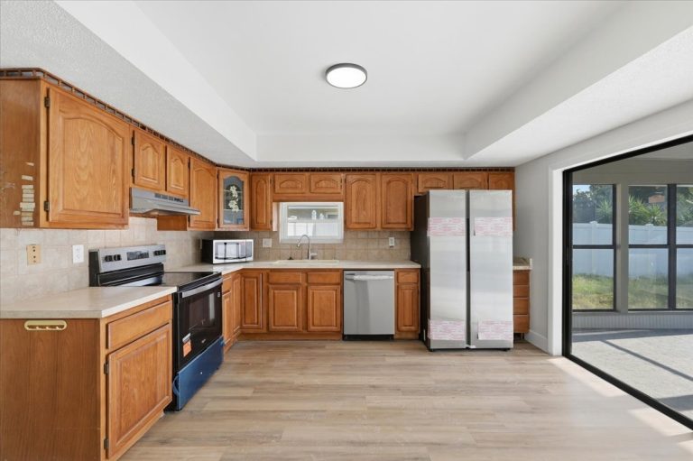 New renovated Kitchen with light brown upper cabinets and white countertops