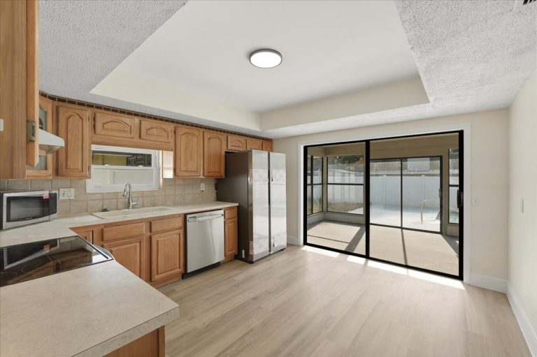 New renovated kitchen with large glass doors leading to the backyard and pool