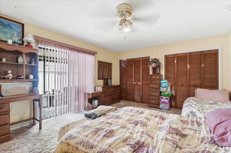 Master Bedroom with brown closets and a large window