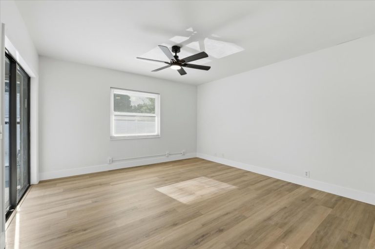New renovated bedroom white walls, fan on the ceiling