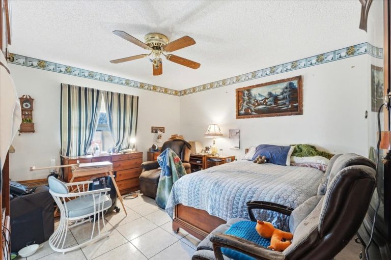 Bedroom featuring double bed, a rocking chair and a large window