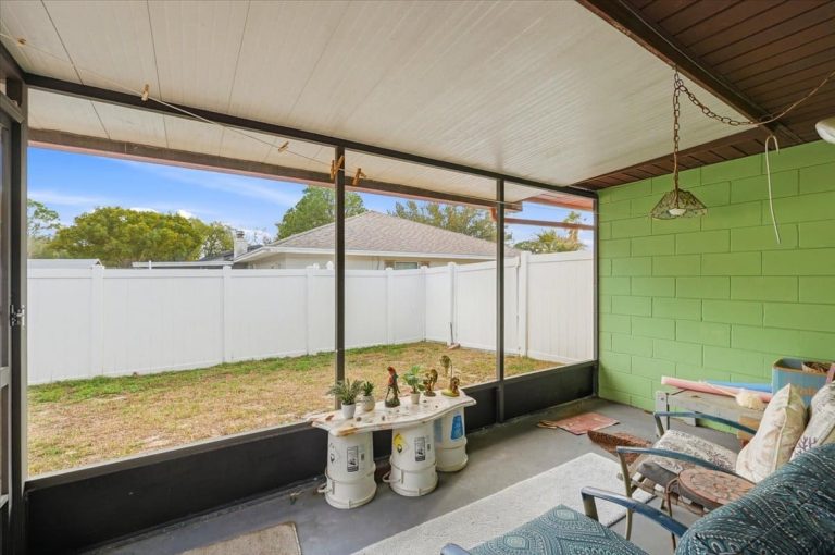 closed-in patio in a East Heron home with a green wall and black framed windows