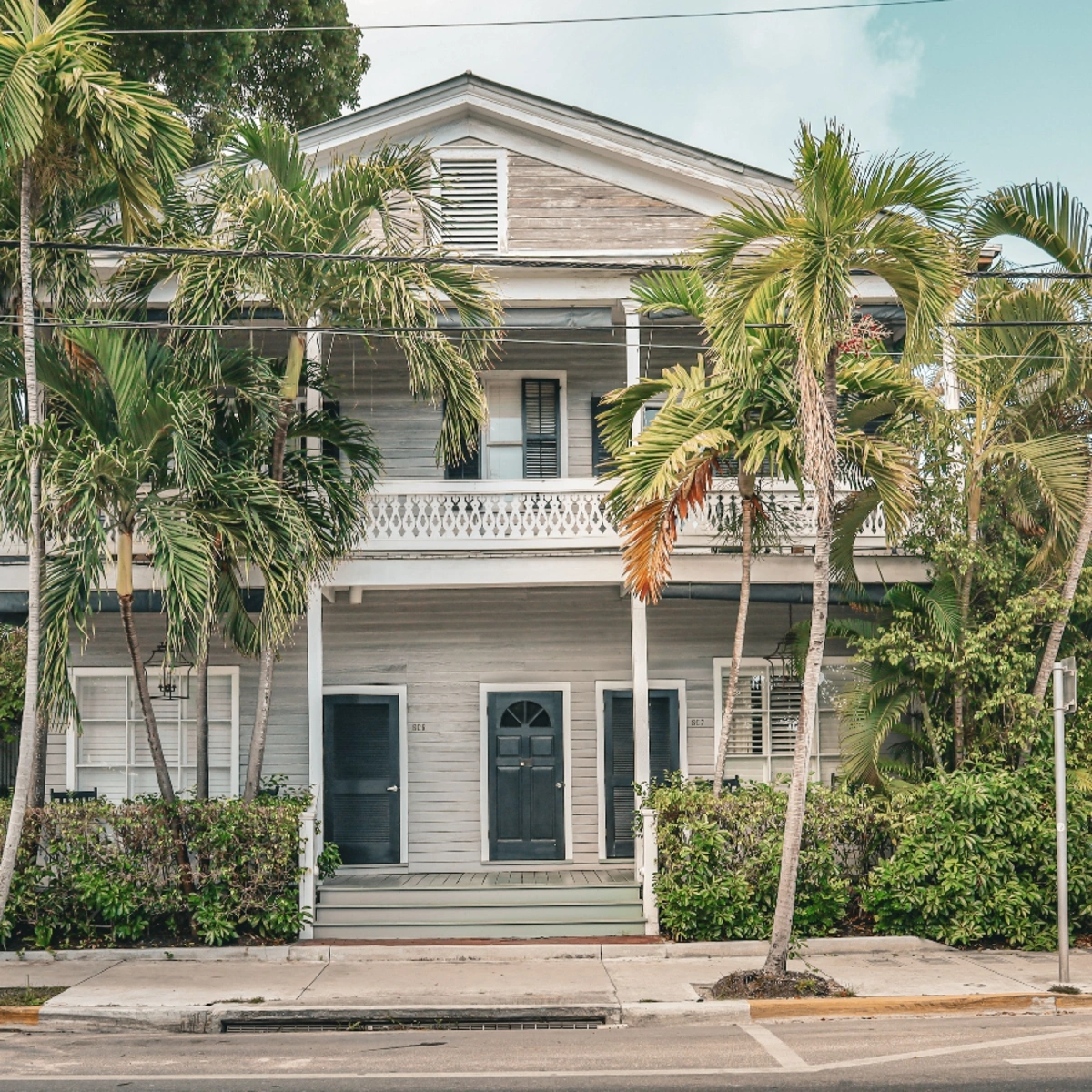 Historic two-story wooden home with wraparound porches in Carver Heights, Deerfield Beach
