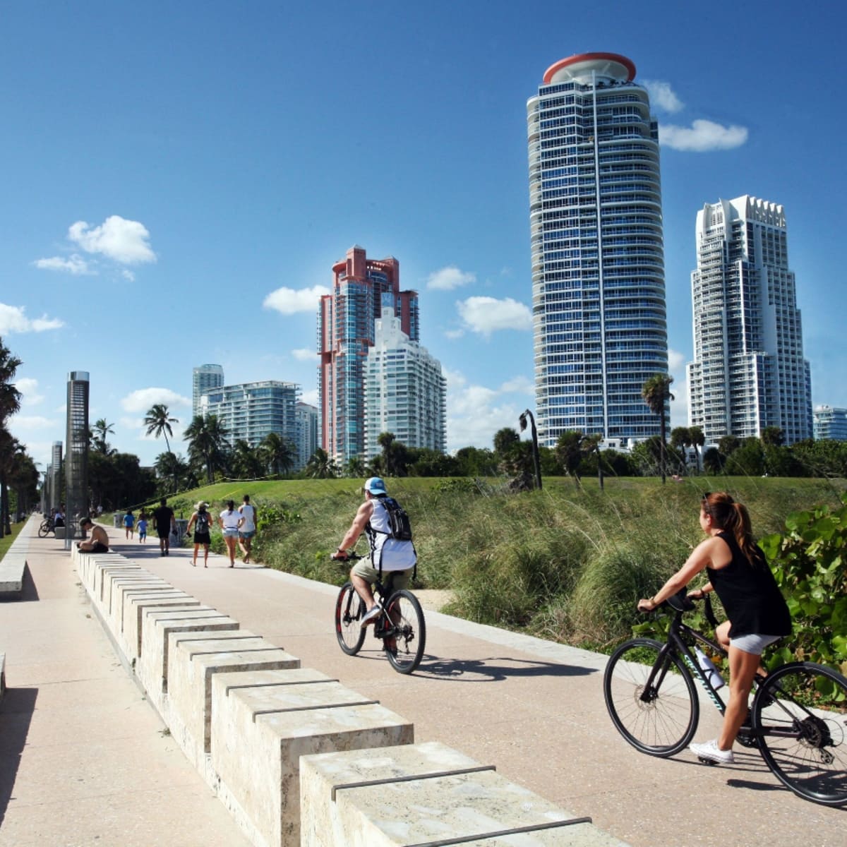 Cyclists and pedestrians on a beachfront path with high-rises in East Port Orange