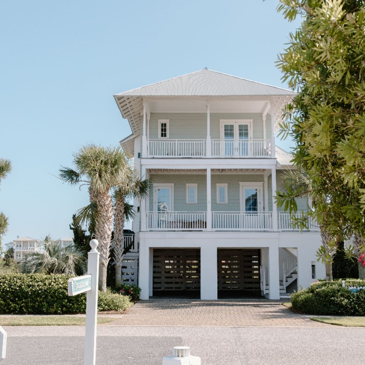Elevated white brick home on stilts with garage in Fox Trail, Loxahatchee