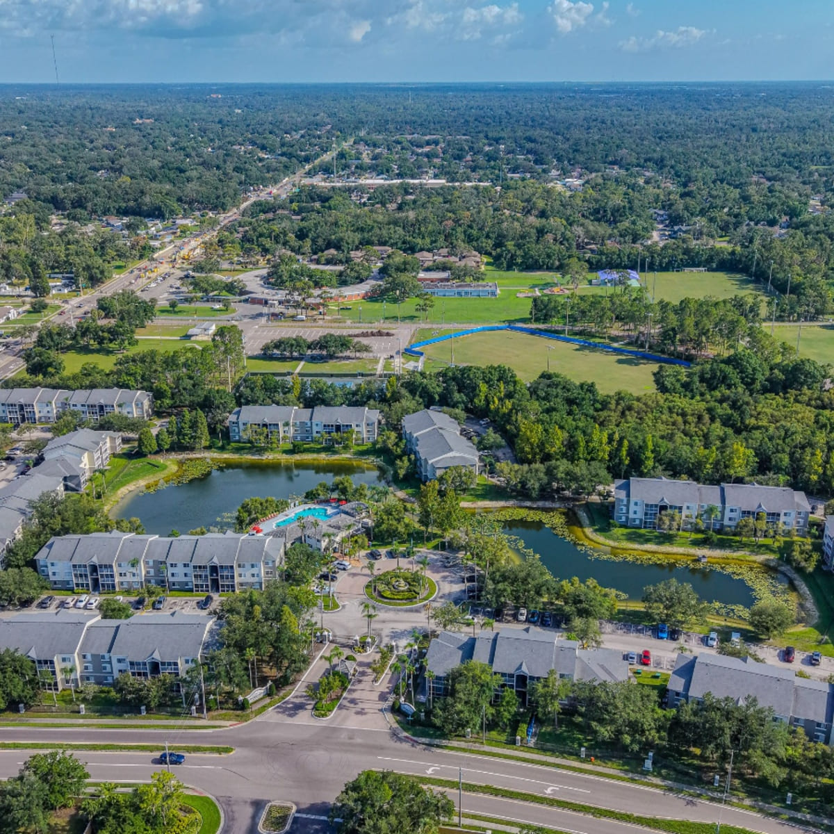 Aerial view of apartment complex with lake and pool in Loxahatchee Groves