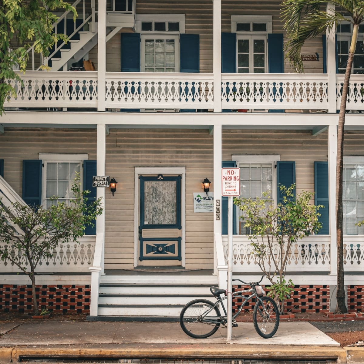 Two-story wooden building with wraparound porches and a bicycle in North Port Orange.
