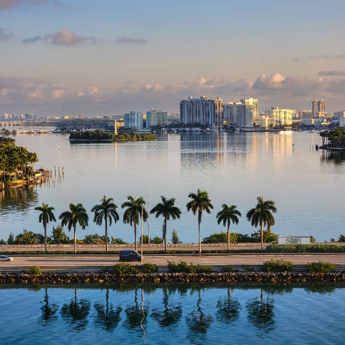 Waterway view of high-rise skyline lined with royal palms near Royal Palm Yacht & Country Club, Boca Raton