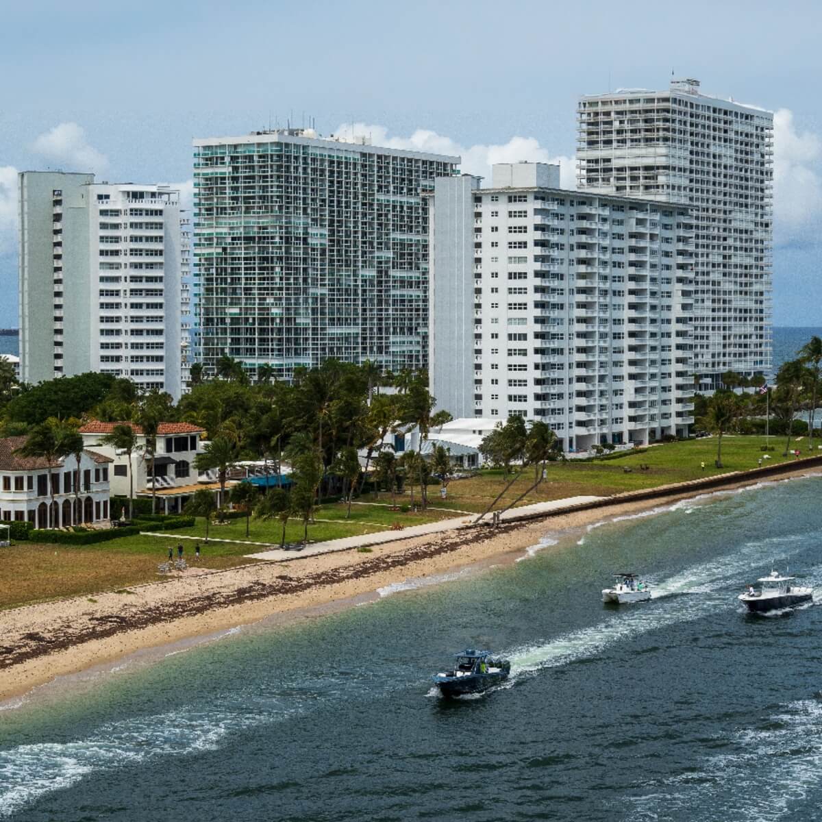 Oceanfront high-rise condos and beach with boats offshore in Seagate, Delray Beach