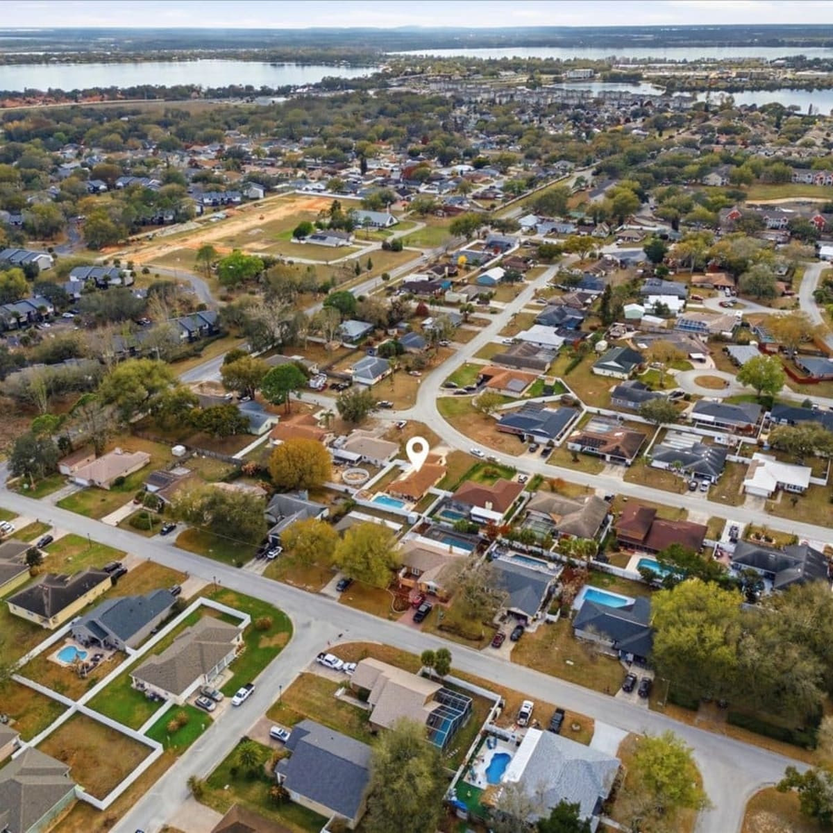 Aerial view of a residential neighborhood with a marked property location in Summer Trees, Port Orange, FL
