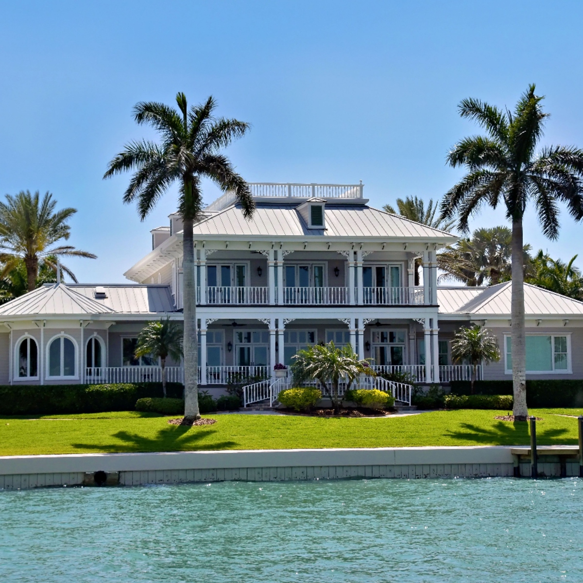 Elegant waterfront estate with wraparound porches and palm trees near Witham Field, Stuart
